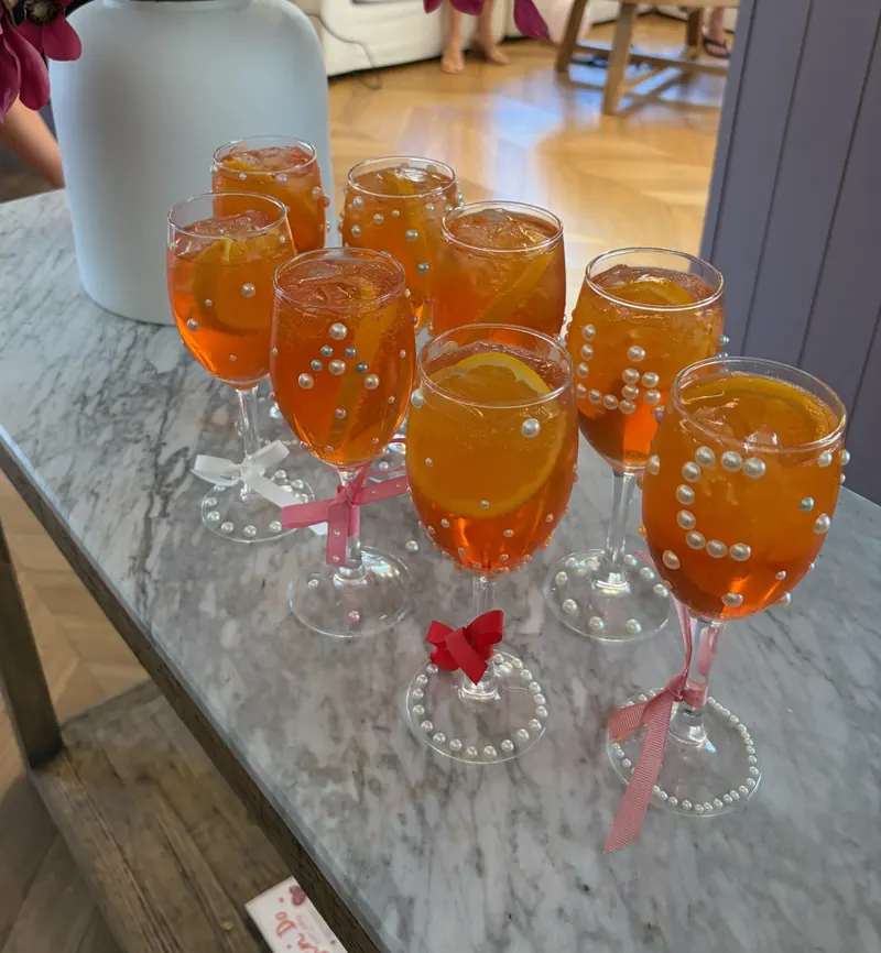 Spritz glasses decorated with pearls and ribbon at a hens party